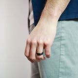 man wearing a tungsten wedding ring with whiskey wood sleeve